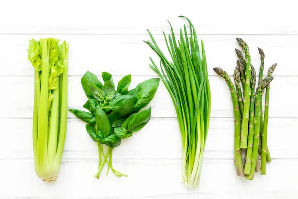 Πράσινα φρέσκα μυρωδικά και λαχανικά σε άσπρο φόντο ξύλινη. Επίπεδη θέσει, φόντο eco για χορτοφάγους — Φωτογραφία Αρχείου
