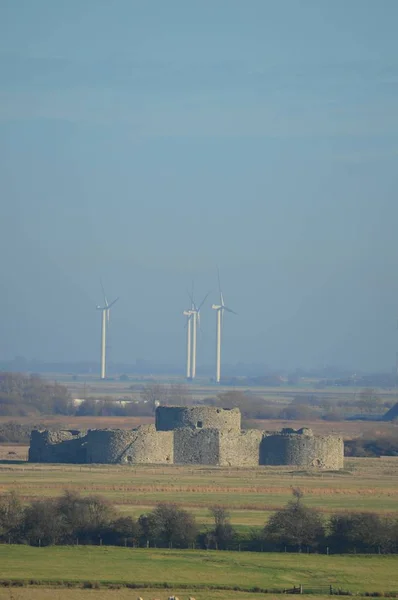 Camber Castle terlihat dari Winchelsea dengan turbin angin di belakang. East Sussex, UK — Stok Foto