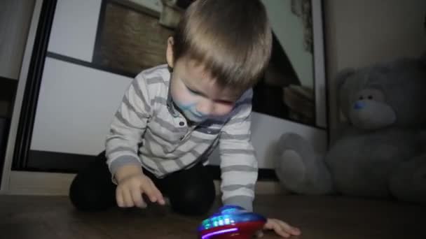 Chlapeček sedí na podlaze a hraje si s hračkami — Stock video