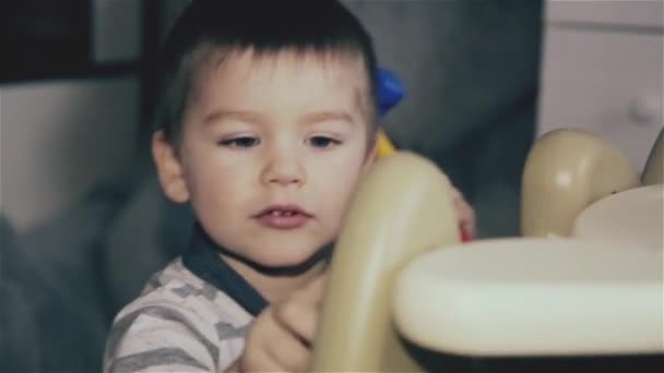 Un niño golpeando un martillo de juguete en la mesa — Vídeos de Stock