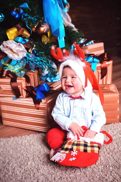 Happy boy is happy and looks at the gifts — Stock Photo, Image