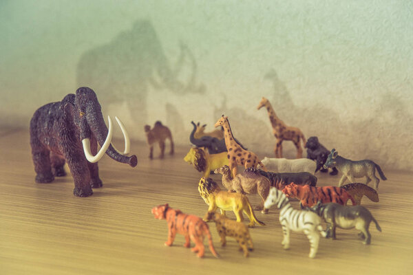 Wild animals against a huge prehistoric mammoth