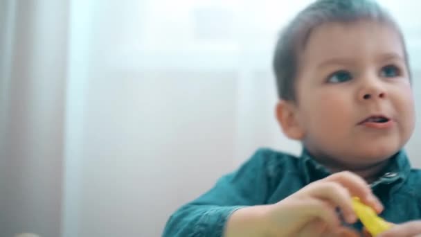 Beau bébé verse du sable cinétique vert dans des moules — Video