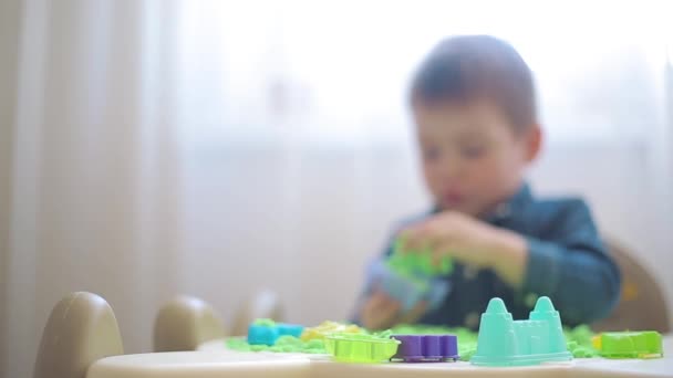 The child plays with kinetic sand and develops motor skills — Stock Video