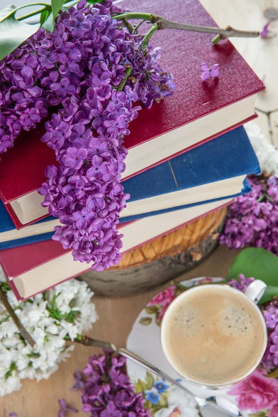 Still life books, coffee and lilacs. Spring background