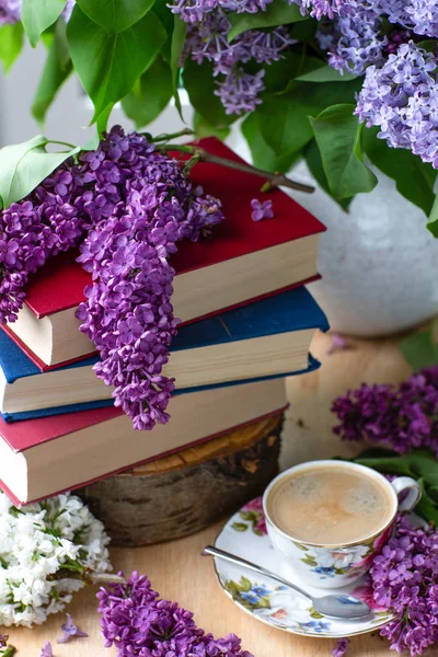 Still life books, coffee and lilacs. Spring background