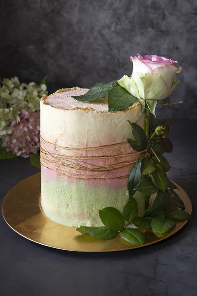 Bolo caseiro O bolo de aniversário é decorado com uma rosa viva em um fundo escuro. Presentes . — Fotografia de Stock