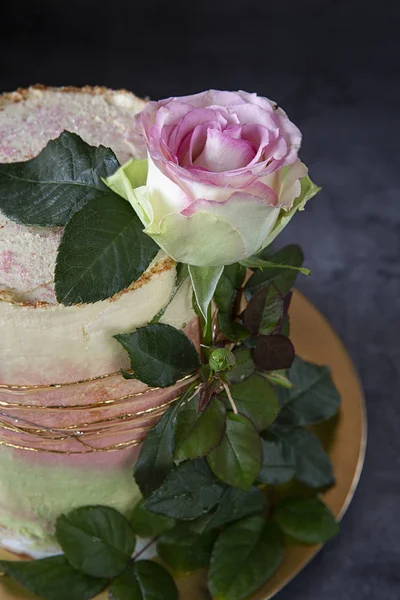 Bolo caseiro O bolo de aniversário é decorado com uma rosa viva em um fundo escuro. Presentes . — Fotografia de Stock