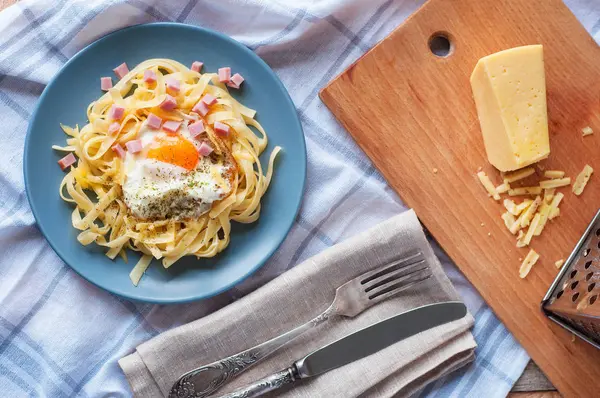 Yumurta, peynir ve otlar ile makarna üstten görünüm. Ekose desenli havlu üzerinde çatal ile Akdeniz flatlay akşam yemeği.
