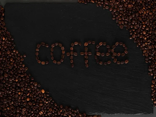 Coffeeped ifade kahve ile koyu arka plan. Kahve çekirdekleri ile siyah tekstüre arka plan.