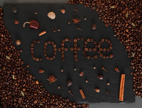 Coffeeped ifade kahve ile koyu arka plan. Kahve çekirdekleri ve baharatlar ile siyah tekstüre arka plan.
