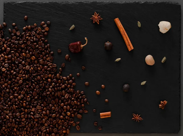 Café en grains flatlay. Photo chaude avec grains de café et épices sur fond texturé foncé . — Photo