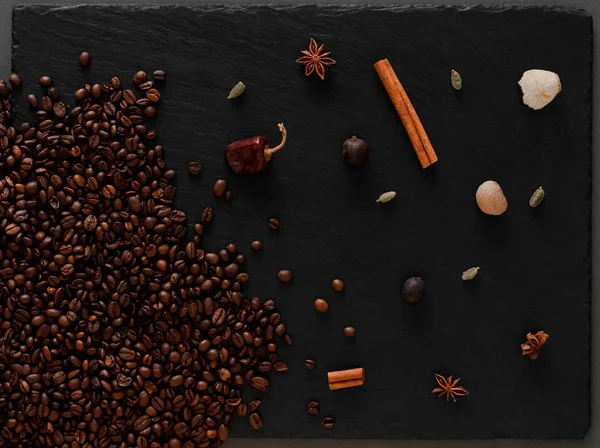 Kahve çekirdekleri flatlay. Kahve çekirdekleri ve baharat karanlık tekstüre arka plan üzerinde sıcak fotoğraf.