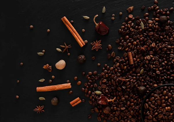 Kahve çekirdekleri flatlay. Kahve çekirdekleri ve baharat karanlık tekstüre arka plan üzerinde sıcak fotoğraf.