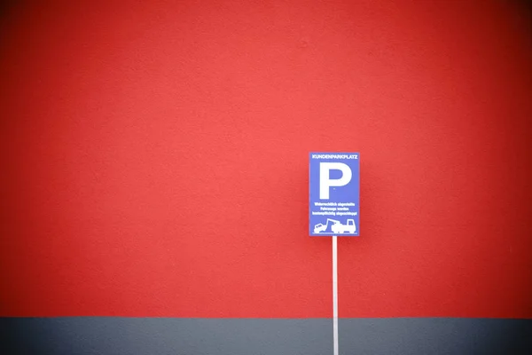 Señal de aparcamiento en la pared roja —  Fotos de Stock