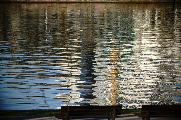 Park benches on the abstract water — Stock Photo, Image