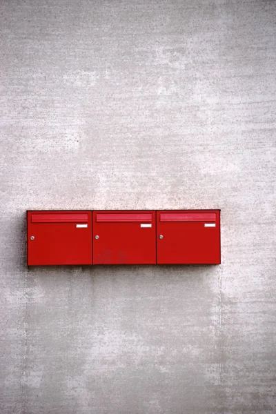 Boîtes aux lettres rouges sur mur rugueux — Photo