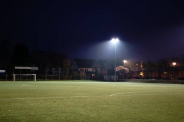 Işıklı futbol sahası gece / gece futbol sahasının yeşil çim tarafından projektörler aydınlatılmış.                           