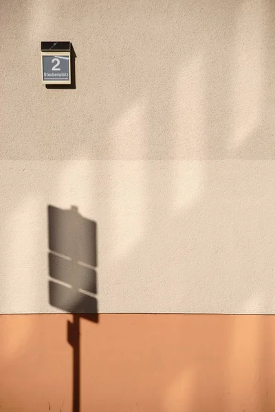 影子路标 路标用房屋号在房屋墙上抛出抽象阴影 — 图库照片