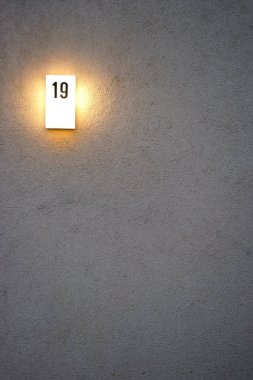  Akşam ev plaka ışıklı / bir ışıklı ev numarası close-up bir konut bina cephe üzerinde oturum.                        