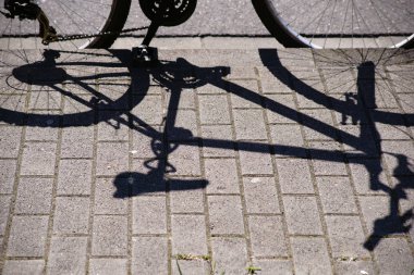 Bisiklet atar gölge / gölgeni kaldırımda park edilmiş bir bisiklet.                       