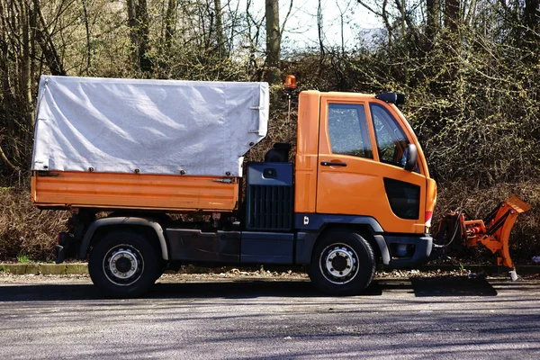 Clearing vehicle with plow / The side view of a small clearing vehicle with plow and loading area.