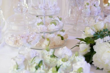 Şeker çubuğu: beyaz masa örtüsü, cam eşyalar, pastalar, tatlılar, badem kurabiyeleri, krema, üzüm