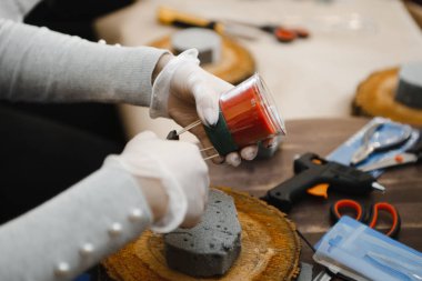 Noel süslemeleri yapmak için kırmızı mumlar, Noel ağacı dalları ve konilerden