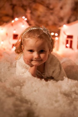 Yapay kar ve küçük mukavva evlerle Noel süslemeleri yapan kız.