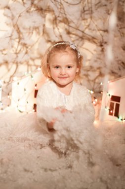 Yapay kar ve küçük mukavva evlerle Noel süslemeleri yapan kız.