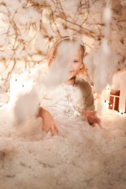 Yapay kar ve küçük mukavva evlerle Noel süslemeleri yapan kız.