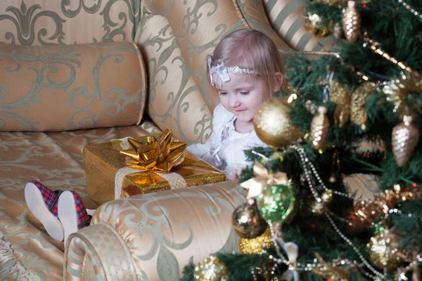 Ragazza Seduta Divano Vicino Albero Natale Decorato Tiene Regalo Ben — Foto Stock