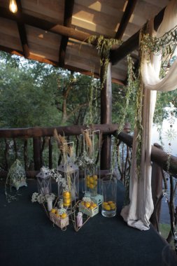 Verandayı dekoratif tezgahlarla süslemek, dekoratif lambaları mumlarla süslemek, kutuları limonlarla doldurmak.