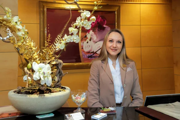 Yönetici ziyaretçileri gülümseyerek karşılar.