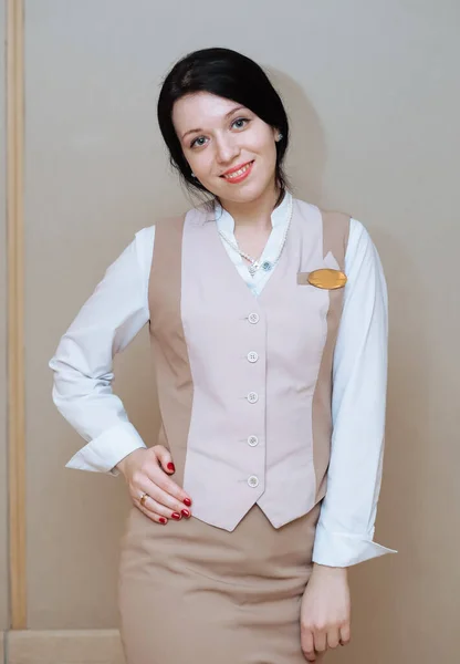 Vrouw Beige Uniform Een Grijze Achtergrond — Stockfoto
