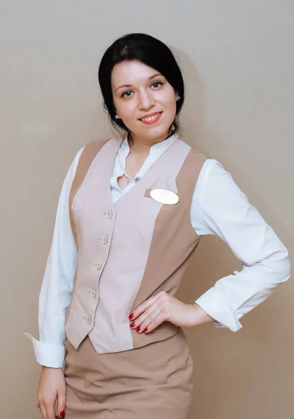 Vrouw Beige Uniform Een Grijze Achtergrond — Stockfoto