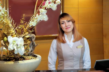 Yönetici ziyaretçileri gülümseyerek karşılar.