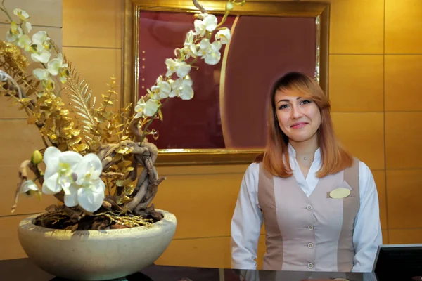 Yönetici ziyaretçileri gülümseyerek karşılar.