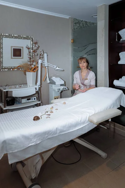 Massagetherapeutin Sitzt Der Nähe Eines Massagetisches Und Bereitet Sich Auf — Stockfoto