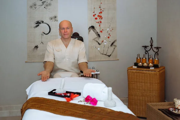 Masażysta Siedzi Przy Stole Masażu Pokoju Masażu Stylu Azjatyckim — Zdjęcie stockowe