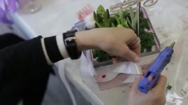 Kırmızı lastik eldivenli kadın saksılara bant yapıştırıyor.