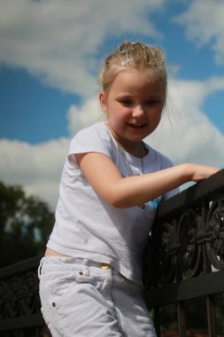 Kız sahte korkuluklara tırmandı.