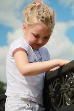 Kız sahte korkuluklara tırmandı.
