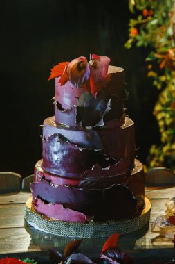 Zantedeschian çiçeğiyle süslenmiş üç katlı pasta, kırmızı yapraklar ve 