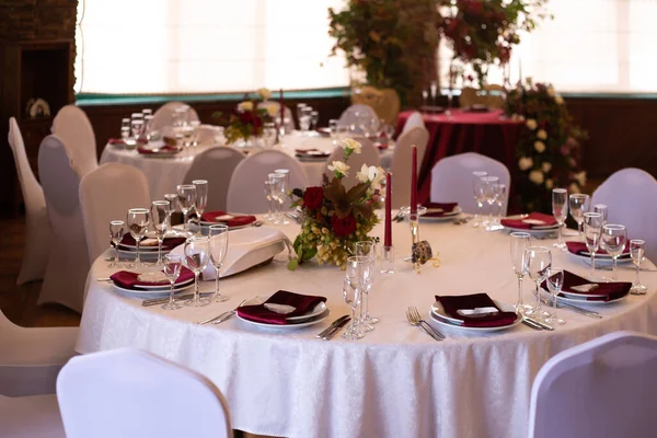 banquet round tables decorated with a bouquet in the center of the tables