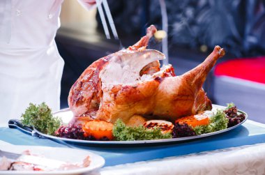 Aşçı kızarmış hindiyi keser.