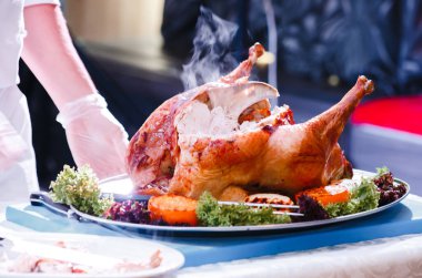 Aşçı kızarmış hindiyi keser.