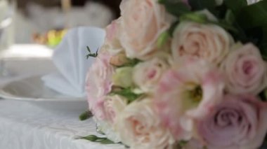 Kamera pembe gül buketinden uzaklaşıyor ve ona odaklanıyor.