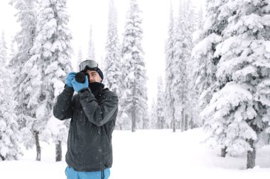Karlı bir ormanın ortasında çekim adam