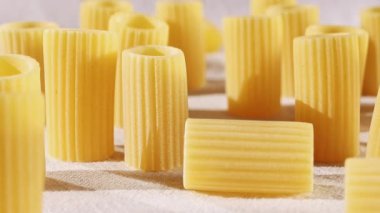 Beyaz pamuklu kumaş üzerine mezzi rigatoni denilen İtalyan makarnası. Uzunluklarında çıkıntılar olan tüp şeklinde makarna. 